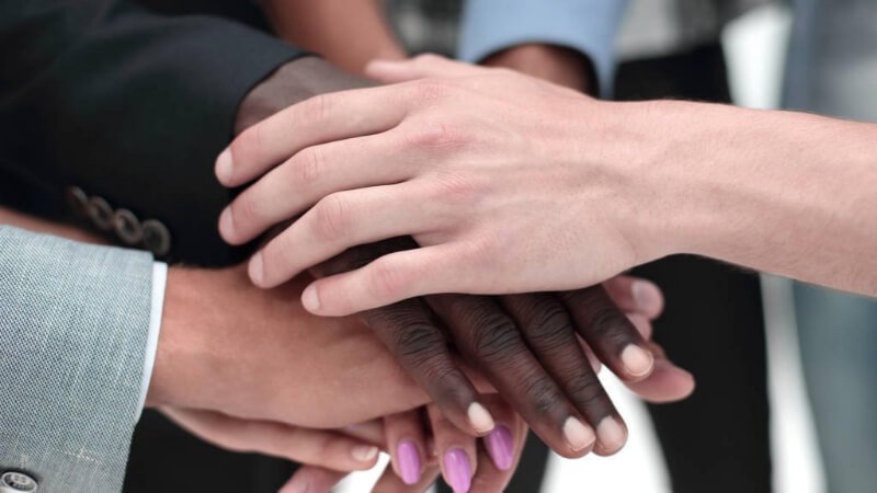 group of people in circle touching hands
